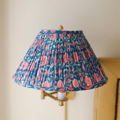 a lamp that is on top of a table next to a wall mounted light fixture