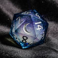 a blue and white dice sitting on top of a black cloth covered surface with the number eight