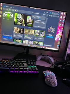 a computer monitor and keyboard sitting next to each other in front of a large screen