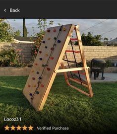 a child's wooden climbing frame in the grass