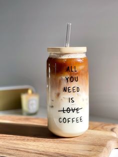 a mason jar filled with liquid sitting on top of a wooden tray next to a cup