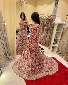 a woman in a red and white dress looking into a mirror