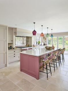 a kitchen with an island and several stools in front of the counter top area