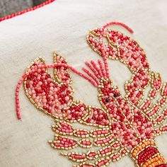 a close up of a pillow with beaded designs on the front and back of it