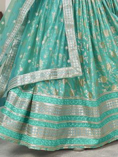 Introducing our captivating sea green zari embroidered jacquard lehenga choli, a stunning ensemble that is sure to make you stand out at any wedding or special occasion. This beautiful lehenga features intricate zari embroidered work and sequin embellishments, adding a touch of glamour and elegance to your look.
The sea green color of the lehenga is absolutely mesmerizing, creating a striking and eye-catching appearance. The jacquard fabric adds a luxurious touch to the outfit, giving it a rich Festive Green Embroidered Lehenga, Green Art Silk Lehenga With Zari Work, Green Art Silk Lehenga For Festive Occasions, Green Bollywood Art Silk Lehenga, Bollywood Style Green Art Silk Lehenga, Green Art Silk Lehenga With Dupatta, Green Lehenga With Zari Work For Navratri, Bollywood Green Lehenga With Zari Work, Green Zari Lehenga For Diwali