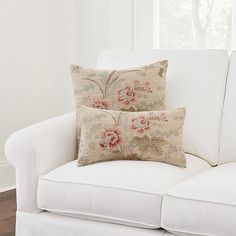 two pillows sitting on top of a white couch