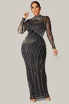 a woman in a long black dress with sheer sleeves and sequins on it