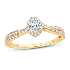 a rose gold engagement ring with diamonds on the band and an oval shaped center stone