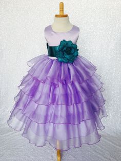 Beautiful organza ruffled dress tailor-made and ready to impress at any upscale event! Handcrafted with the upmost of care and attention to detail, we make sure that each dress is perfectly one of a kind for your little girl. Bridal satin top followed by a satin sash for a nice and snug fit Comes with a flower and matching colored sash. The skirt has layers of cut organza strips which are sewn onto the lining to create the ruffled effect The organza is then sewn at the edges to create those cris Organza Ruffle Dress, Flower Girl Gown, Satin Sash, Gowns For Girls, Ruffled Dress, Lilac Dress, Wedding Bridesmaid, Gown Wedding, Satin Top