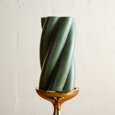 a green vase sitting on top of a wooden table