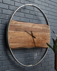 a clock mounted to the side of a brick wall next to a potted plant