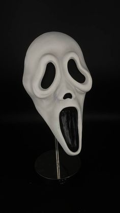 a white mask with an open mouth on a black background