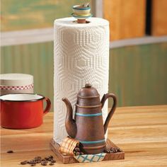 an old fashioned tea kettle and two cups on a wooden table next to each other