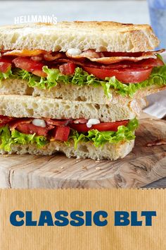 a sandwich cut in half sitting on top of a wooden cutting board