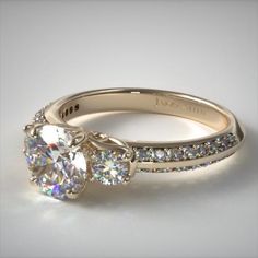 a white gold engagement ring with two round diamonds on the sides and side stones in the middle