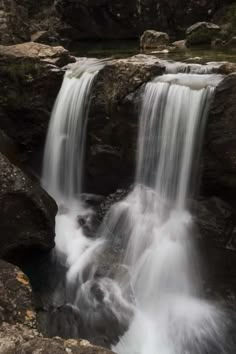 a small waterfall is flowing over rocks