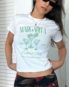 Margarita Club Baby Tee, Coquette Shirt, Margarita Shirt, Vintage Tee, Y2K Aesthetic, Cocktail T shirt, Coquette Top, Marg Time, Tequila *IMPORTANT PLEASE READ BEFORE PURCHASING* My store uses DTG (Direct to Garment) printing. This means the design is printed into the garment. This means it is designed to last longer than other printing processes. Due to this printing process the design colors may not be as vibrant as shown in the photos. There may at times be a slight difference between real an Retro Fitted Printed T-shirt, Fitted Letter Print Tops For Summer, Green Fitted Top With Letter Print, Fitted Green Tops With Letter Print, Fitted Printed Graphic Tee Shirt, Fitted Graphic Tee With Print, Fitted Short Sleeve Top With Screen Print, Fitted Printed Graphic Tee, Fitted Screen Print Tops For Spring