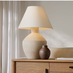 a table lamp sitting on top of a wooden dresser