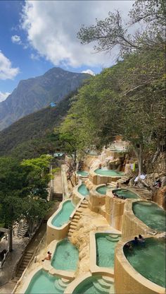 an outdoor swimming pool surrounded by trees and mountains