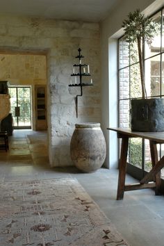 a large vase sitting on top of a wooden table in a living room next to a window