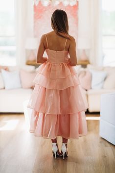 the back of a woman's dress as she stands in front of a couch