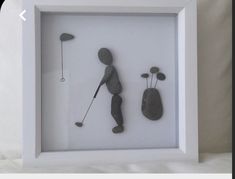 a shadow frame with two rocks and a golf player