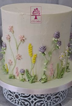 there is a cake decorated with flowers on the top and bottom layer, along with other decorations