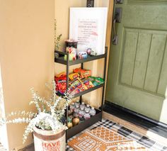 a shelf filled with candy and snacks next to a green door on the side of a building