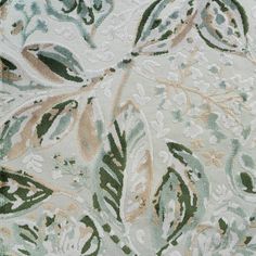 an area rug with green and white leaves on it