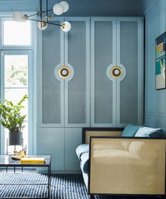 a living room with blue walls and white trimmings on the wall, two lamps hanging from the ceiling