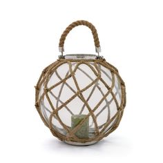 a glass lantern with rope wrapped around it and a small candle in the center, on a white background