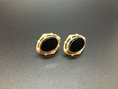 This is a classic and timeless set of earrings marked 12K Gold Filled with "CM" in the center of the screw back.  The setting is rich, gold-filled surrounding a polished black stone (perhaps onyx, perhaps glass) that has elegant beveled edges.  The stone has a smooth, mirror finish.  These earrings are in beautiful, vintage condition, measuring approximately 3/4" by 5/8" . Classic Black Clip-on Earrings For Formal Occasions, Formal 14k Gold Earrings With Screw Back, Antique Black Earrings For Formal Occasions, Vintage Black Earrings For Anniversary, Jeweled Bouquet, Black Stone Earrings, Frame Wreath, Screw Back Earrings, Black Stone