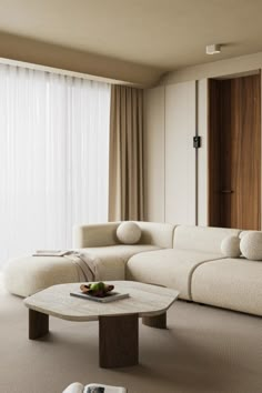 a living room filled with furniture and a book on top of a table in front of a window