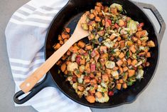 a skillet filled with chopped vegetables on top of a white and gray table cloth