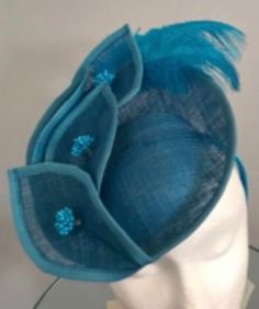 "Sinamay blue disc with sinamay formed leaves, and blue ostrich feathers - very European looking - all mounted on a headband - perfect for racetrack! This is a stylish fascinator - great for Breeders' Cup, the Kentucky Derby, any racetrack or Steeplechase, Polo Matches, Wedding, Garden Party, Afternoon Tea, Easter, Mother's Day or Church....anywhere that a beautiful fascinators de rigeur. Each fascinator is one of a kind, handcrafted in Louisville, KY home of the prestigious Kentucky Derby. Don' Adjustable Blue Headband Costume Hat, Blue Adjustable Headband Costume Hat, Adjustable Blue Costume Headband, Blue Handmade Flowers Fascinator For Races, Adjustable Blue Headband For Kentucky Derby, Blue Adjustable Headband Fascinator, Adjustable Blue Headband Fascinator, Blue Feather Trim Mini Hat For Kentucky Derby, Blue Feathered Fascinator For Summer