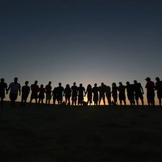 a group of people standing on top of a sandy beach