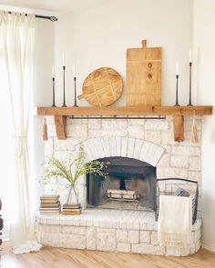 a living room with a fire place and some candles on the mantel above it