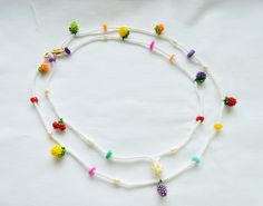 a white beaded necklace with multi colored beads