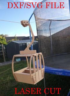 a wooden ski lift sitting on top of a grass covered field next to a net