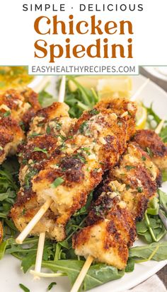 chicken skewers on a plate with spinach and lemon wedges in the background