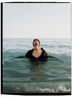 a man floating in the ocean with his eyes closed