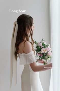 a woman in a white dress holding a bouquet of flowers with the words long bow above her head