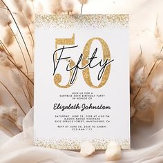 an elegant 50th birthday party with gold glitter on the card and white paper in front