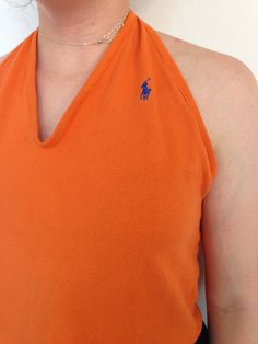 This reworked vintage Ralph Lauren orange halter top is perfect for the summer! Cropped below the belly button, this shirt is backless so you can perfect your glowing tan while looking glamorous *and* being environmentally friendly by shopping vintage! What better combination could there be?  ONLY ONE. UTTERLY UNIQUE. Length from shoulder to hem: 17 inches Fitted V-neck Tops For Beach Season, Stretch Halter Neck Tops For Beach Season, Fitted Backless Summer Tops, Summer Stretch Backless Tops, Fitted Halter Neck Tank Top For Beach Season, Fitted Backless Beach Top, Vintage Stretch Summer Tops, Vintage Stretch Tops For Summer, Orange Cropped Top For Beach