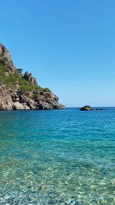 clear blue water with rocks in the background