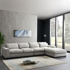 a living room with a large sectional couch in the middle and a painting on the wall