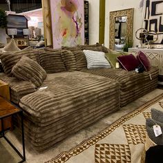 a large couch sitting on top of a rug in a room filled with lots of furniture