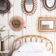 a bed sitting under three mirrors on the wall