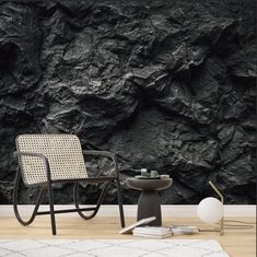 a chair and table in front of a black rock wall