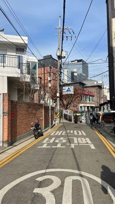 a motorcycle is parked on the side of an empty street with buildings in the background